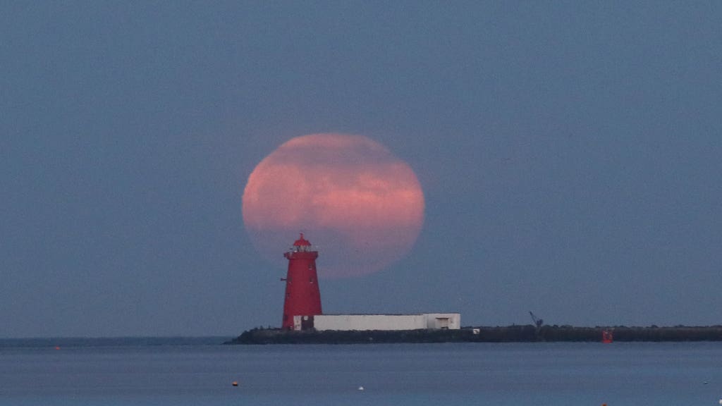 Pink supermoon over lighthouse